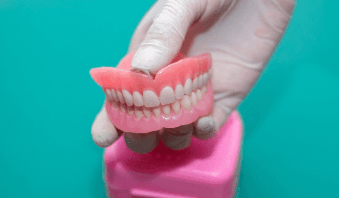 Prótesis dental completa superior e inferior en mano profesional, Clínica Dental RM en Montequinto, Dos Hermanas.